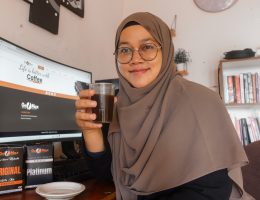 riafasha duduk di depan komputer minum kopi