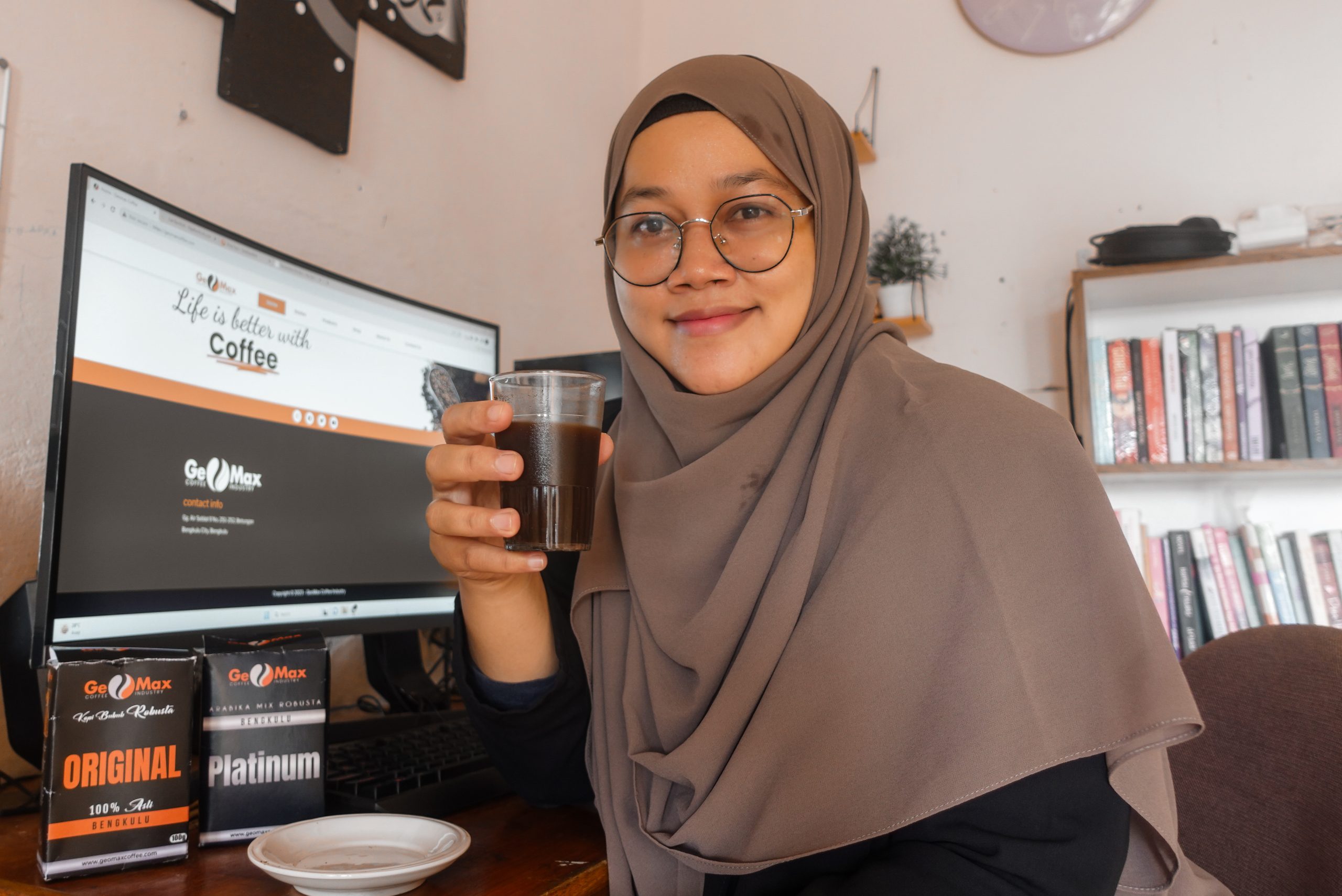 riafasha duduk di depan komputer minum kopi